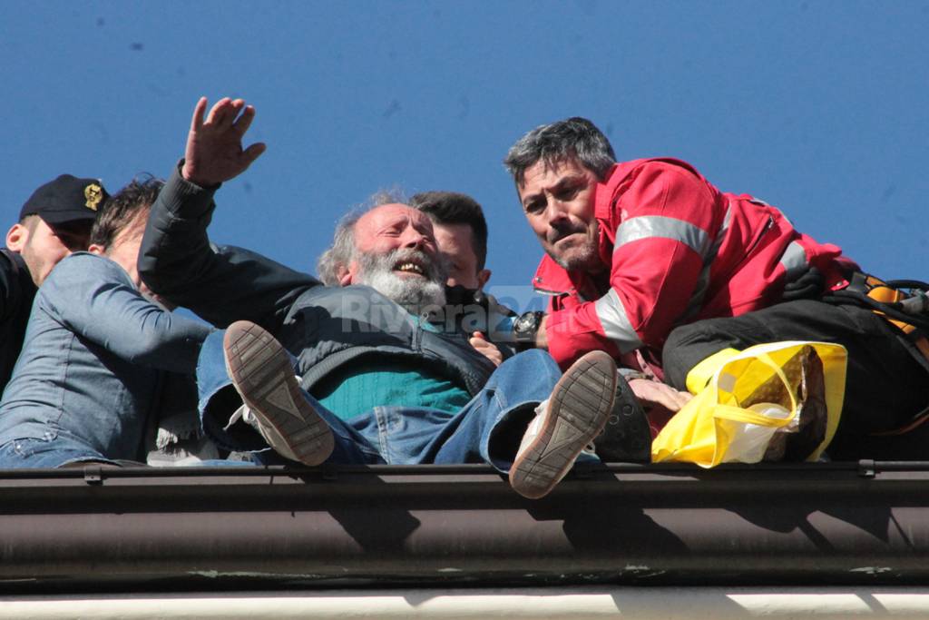 Folle minaccia di lanciarsi dal tetto di un palazzo: i soccorritori lo agguantano prima che sia troppo tardi